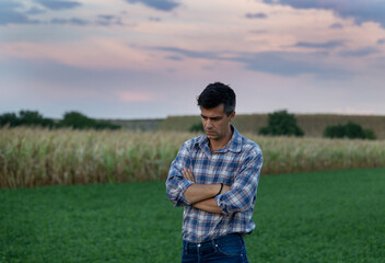 Unhappy farmer standing in field after drought