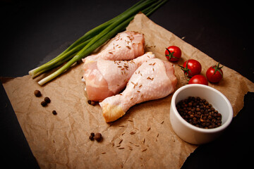 Raw chicken thigh on black background