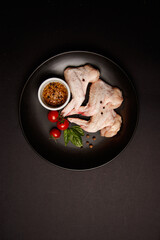 Raw chicken thigh on black background