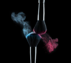 Black cosmetics eyeshadow brushes with colorful make-up powder splashes on black background