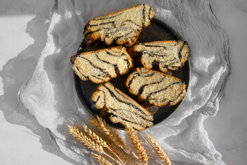 Appetizing bun with poppy seeds on an old background