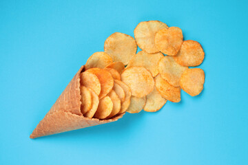 Waffle Cone with Potato Chips on blue background. Fast Food concept