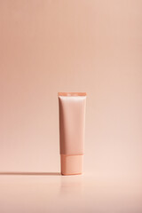 Cosmetic cream or mask in a white tube with hard shadows from the leaves on a white background. Natural organic care for face and body skin. View from above.