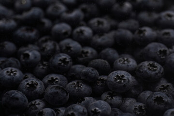 a heap of fresh ripe wet blueberries under water filling the frame, selective focus, top view, background