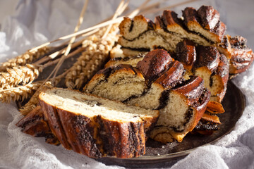 Appetizing bun with poppy seeds on an old background