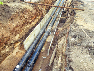black, polypropylene, long pipes are laid underground for communications. construction of a new...