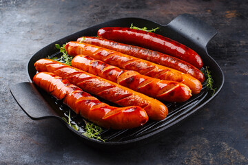 Fototapeta Traditional German barbecue Bratwurst sausages served in a rustic cast iron frying pan obraz