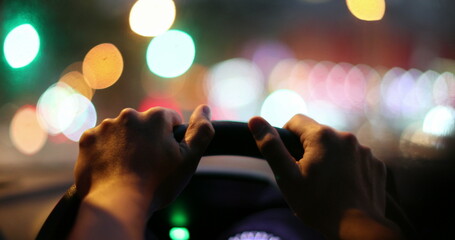 Fototapeta na wymiar Commuter driver POV holding steering wheel driving at night