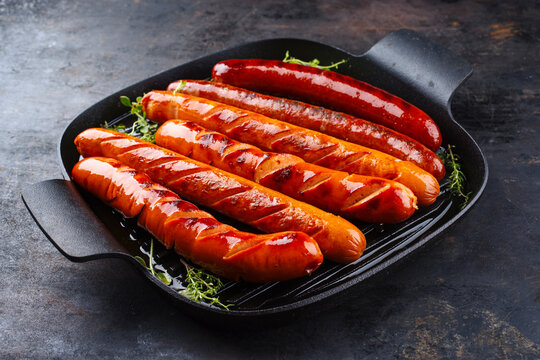 Traditional German barbecue Bratwurst sausages served in a rustic cast iron frying pan