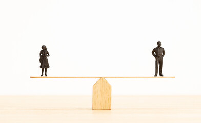 Gender equality concept. Man and woman figurine on a seesaw. Copy space