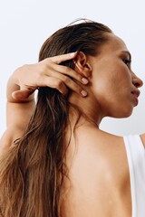 Fototapeta premium A woman with long hair stands back and takes care of her hair after washing and applying scalp and hair health products. Taking care of your hair at home