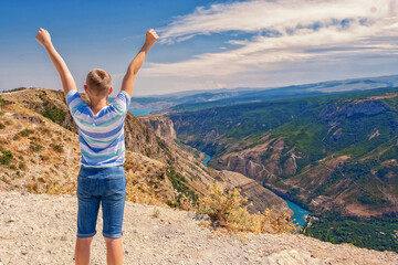 Traveler Teenager boy hands raised mountains landscape. Travel happy emotions success concept summer vacations outdoor