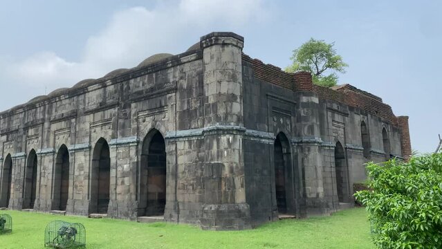 Outside view of the garden in the 12 Gate Mosque or the Baro Shona Masjid surrounded by trees is situated in Gour, West Bengal, India. Goat feeding on the grass
