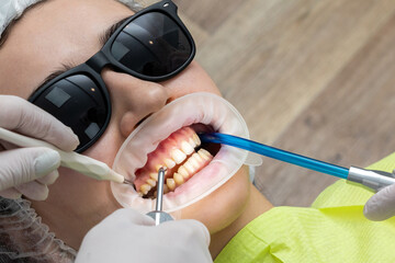 Patient with cheek retractor lying in dentist office