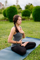 Fototapeta na wymiar Yoga instructor, young woman deep breathing, yoga breathing, ardha padmasana, half lotus, cross legged sitting posture.