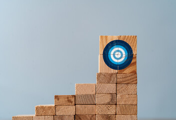 Cllose up photo of ladder made of wooden blocks and target sign on the top as a symbol of climbing...