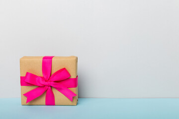holiday paper present tied pink ribbon bow top view with copy space. Flat lay holiday background. Birthday or christmas present. Christmas gift box concept with copy space