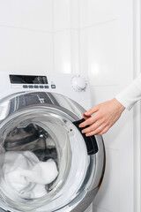 laundry at home, woman load washing machine and close door