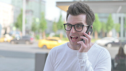 Angry Young Man Talking on Phone Outdoor