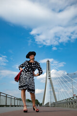A beautiful woman in Warsaw on the Bridge.Elegant woman in a hat. Świętokrzyski Bridge in Warsaw