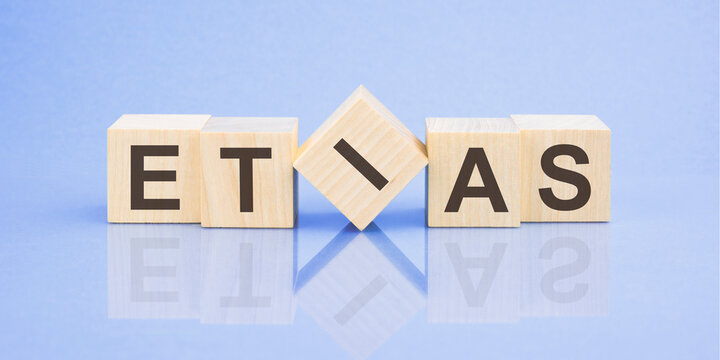 etias word written on wood block for your design, blue background