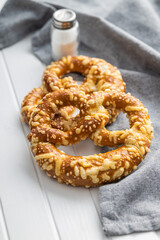 German bread pretzel with baked cheese on kitchen table.