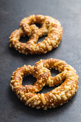 German bread pretzel with baked cheese on kitchen table.