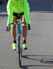 young cyclist with racing bicycle and phosphorescent waterproof jacket