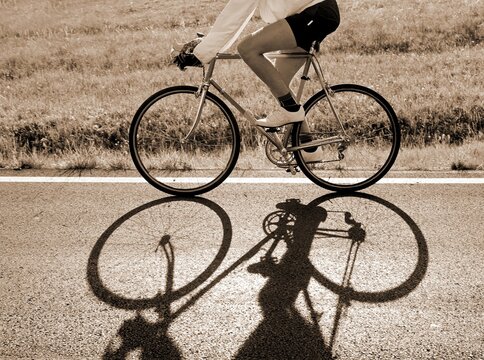 cyclist rides fast against the light with a racing bike on the asphalt road