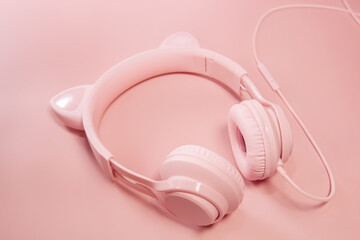 Pink headphones with cat ears on a pink background