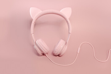 Pink headphones with cat ears on a pink background