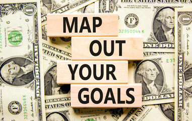 Support and map out your goals symbol. Concept words Map out your goals on wooden blocks on a beautiful background from dollar bills. Business, support and map out your goals concept