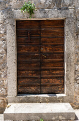 Building's facade. Wall of an old house. Closed door. Architectural detail. Close-up