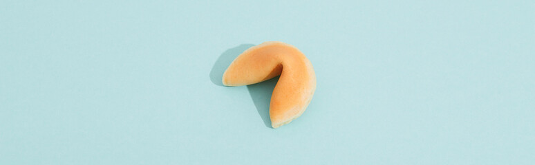 Fortune cookie on a blue background with deep long shadow. Background template for restaurant
