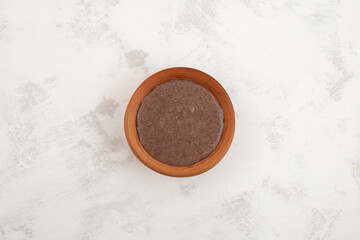 Ragi Porridge or Sweet Ragi Malt in clay bowl, top view. Healthy nutritional drink made from organic finger millet flour  Indian food