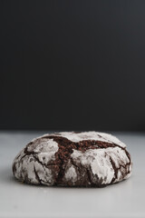 Food photo of freshly baked Chocolate Crinkle Cookies. Close up macro image of a single chocolate iced biscuit. Black and white background with copy space available