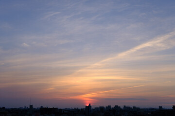 兵庫県神戸市東灘区の高層マンションの上層階からの夜明け。大阪生駒山から太陽が昇り、あたりはオレンジ色に染まり、ビル群がシルエットで浮かぶ