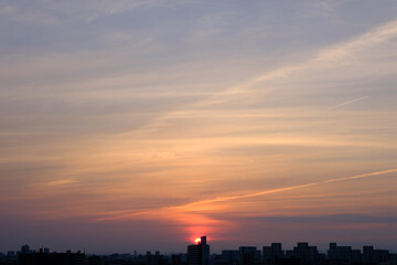 兵庫県神戸市東灘区の高層マンションの上層階からの夜明け。大阪生駒山から太陽が昇り、あたりはオレンジ色に染まり、ビル群がシルエットで浮かぶ