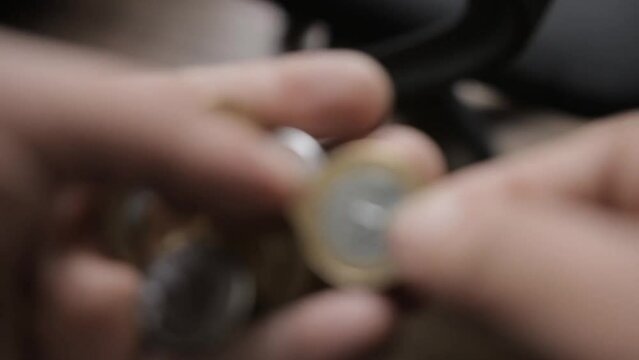 shallow focus shot from a man counting Brazilian Real coins in his hands