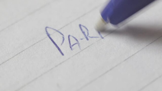 Close up view from a person slowly writing some words in portuguese in a piece of paper 