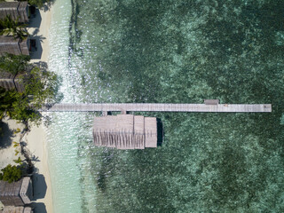 Bird view on the bungalows and the pier on the tropical reef
