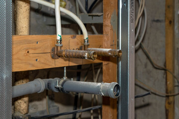 Water and sewer pipes sticking out of the wall in a room where repairs are being made