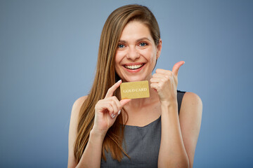Woman smilng and holding gold credit card. isolated portrait with thumb up.