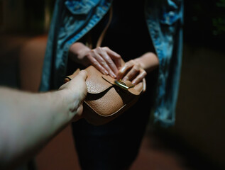 Thief snatches bag from woman on the night street.