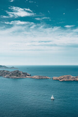 Fototapeta na wymiar Sailboat in freedom in the middle of the ocean enjoying the immensity islands vertical