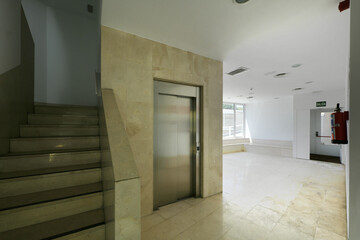Hall of a residential building with elevator and marble stairs © Toyakisfoto.photos