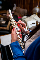 Fototapeta premium Hands of a girl with painted nails cleaning a silver transverse flute