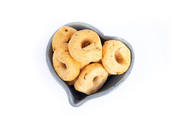 Tarallini or Taralli an Italian Snack Ring or Cracker in Blue Pottery Heart Shaped Bowl Isolated on White in a Flat Lay or Top Down View