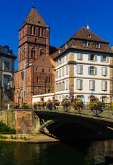 Scenic view of Strasbourg cityscape on sunny summer day overlooking historical building of St Thomas Church on bank of Ill river a