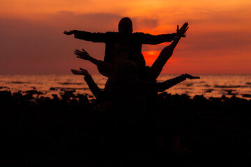 silhouette of a few people at sunset on the beach